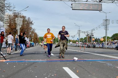 15 Eylül 2019 Minsk Belarus Mutlu Katılımcılar bitiş çizgisine koşuyor. Bir adam telefonuyla atletlerin fotoğraflarını çekiyor.