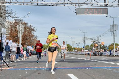 15 Eylül 2019 Minsk Belarus maratonu. Elinde akıllı telefon olan bir kadın maratonun bitiş çizgisini geçiyor.