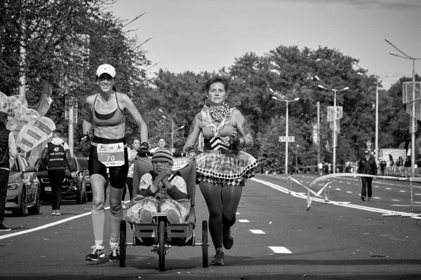 2019年9月15日ミンスク ベラルーシ黒と白では 車椅子の女性2人と障害のある少女を含むマラソンレースが都市の道路上でマラソンを走ります — ストック写真