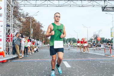 9 Eylül 2018, Minsk Belarus Yarı Maraton Minsk 2018, maratonun bitiş çizgisinden sonra koşan gözlüklü katılımcı.