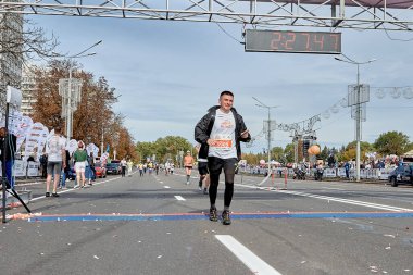 15 Eylül 2019 Minsk Belarus maratonunun bitiş çizgisini elinde akıllı bir telefonla geçen mutlu bir atlet..