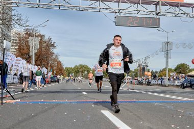 15 Eylül 2019 'da Minsk Belarus maratonunda akıllı telefonlu mutlu bir sporcu bitiş çizgisini geçti.