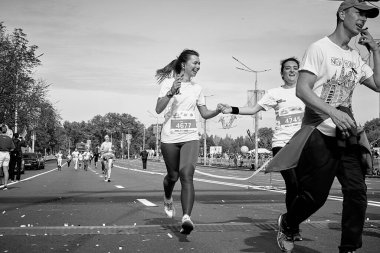 15 Eylül 2019 Minsk Belarus mutlu kadınların telefonda bir atlet varken bitiş çizgisini geçtikleri bir maraton yarışı.