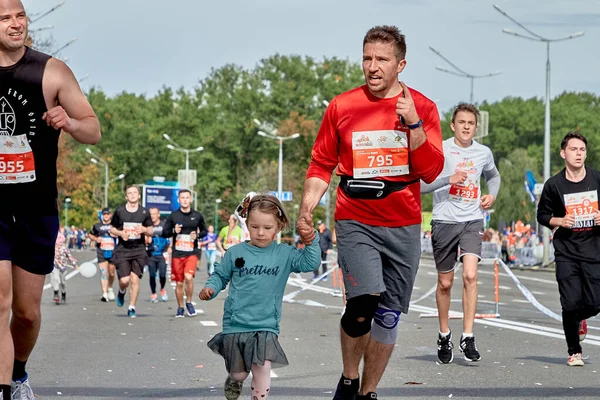 2019年9月15日白俄罗斯明斯克一名感情激动的父亲和女儿与一群运动员在城市公路上跑马拉松的特写镜头 — 图库照片