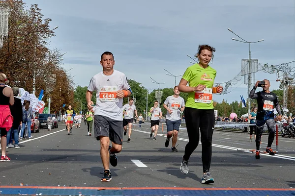 2019年9月15日明斯克白俄罗斯半程马拉松赛明斯克2019年一位参赛者跨过马拉松赛的终点线 用智能手机检查了心率监测器 — 图库照片