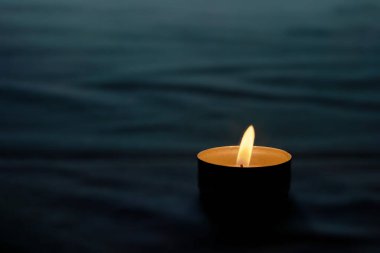 In memory of the victims, a candle is lit on a black background.Memorial day