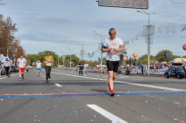 15 Eylül 2019 'da Minsk Belarus' ta yaşlı bir adam maratonun bitiş çizgisini akıllı adımlarıyla kalp atışlarını kontrol ederek geçer.