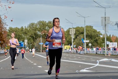 15 Eylül 2019, Minsk Belarus. Şehir yolunda koşan genç bir kadının yakından çekildiği bir maraton yarışı.