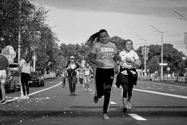 15 Eylül 2019 Minsk Belarus Siyah beyaz bir maratonda iki aktif rakip bir şehir yolunda koşuyor.