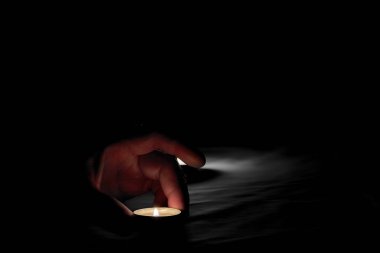 Unutulmaz bir günde, bir insan yanan bir mumu, yanan bir mumun yanına koyar.