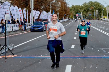 15 Eylül 2019 Minsk Belarus mutlu bir sporcu maratonun bitiş çizgisini katılımcıların önünde geçiyor.