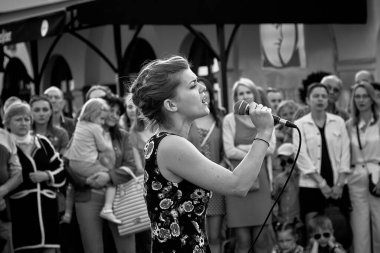 May 25, 2019 Minsk Belarus In black and white, a theatrical performance in which a close-up of a young beautiful woman with a microphone sings on the street