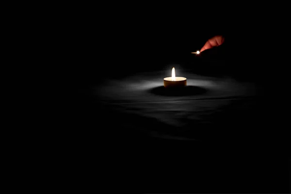 纪念日那天 一个人的手在无色的桌子上放着一根炽热的蜡烛 — 图库照片