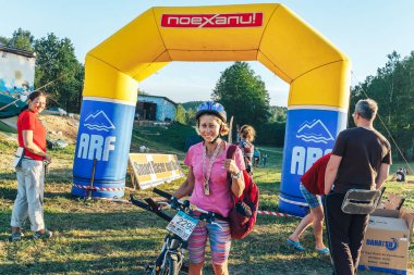 26-27 Mayıs 2018 tarihleri arasında Naliboki, Beyaz Rusya amatör maratonu. Bitiş çizgisinin yanında madalyalı bir kadın bisikletçi var.