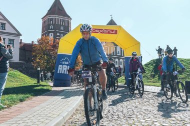 6 Ekim 2018 Novogrudok Belarus Kalesi Yolu Kalenin önündeki maratonun başında taş yolda ilerleyen gözlüklü bisikletçiler var.