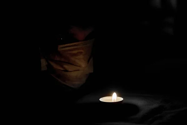 Egy Férfi Orvos Orvosi Maszkban Egy Égő Gyertyát Néz Sötétben — Stock Fotó