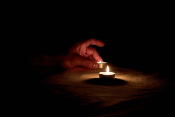 一只人类的手想要把一根燃烧的蜡烛放在桌上以纪念这次纪念活动 — 图库照片