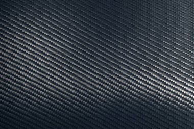 Gri dokuma karbon fiber kompozit yaprağın bükülmüş yüzeyi.