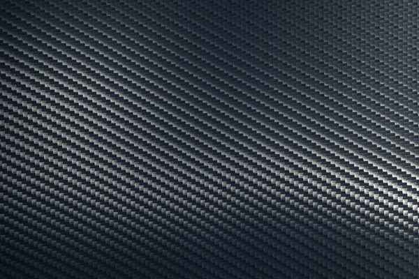 Gri dokuma karbon fiber kompozit yaprağın bükülmüş yüzeyi.