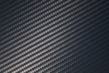 Örülmüş karbon fiber çarşaf yüzeyi. Doku ve şablonun çapraz yönelimi. Modern teknoloji ve malzeme konsepti...