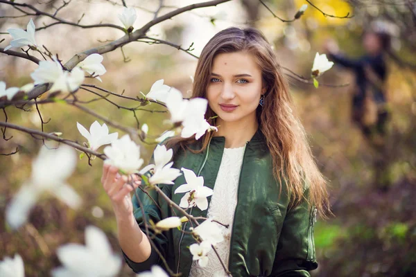 Dívka pózuje v zahradě magnolia — Stock fotografie