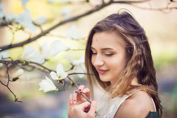 Dívka pózuje v zahradě magnolia — Stock fotografie