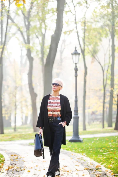 Stylová blondýna v podzimním parku — Stock fotografie