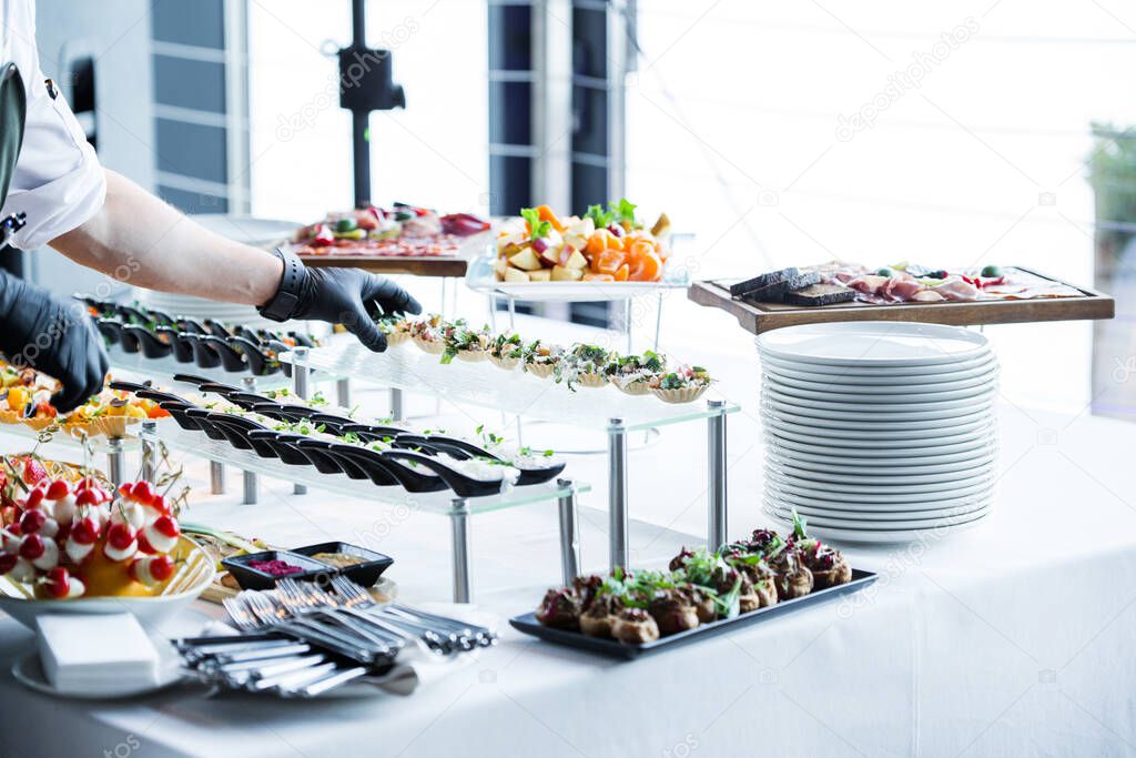 the waiter makes the organization of snacks on the table, before the arrival of the guests