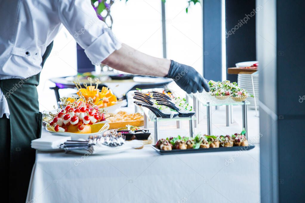 the waiter makes the organization of snacks on the table, before the arrival of the guests