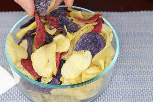 Fingers Choosing Red, Purple and Yellow Potato Chips — Stock Photo, Image