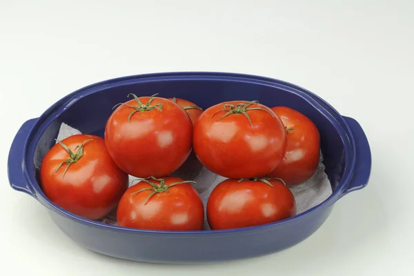 Siedem czerwonych pomidorów w misce niebieski — Zdjęcie stockowe
