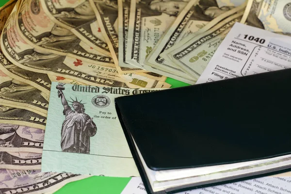 Cheque de reembolso de impostos com dinheiro e livro de cheques — Fotografia de Stock