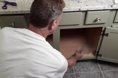 Yetişkin Erkek, Banyo Dolabına Temizlik Çizgisi Yerleştiriyor