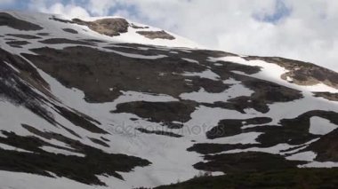 Güneş ışığı ve karlı Dağların üzerinden hareket bulutlar
