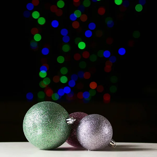 Glänzende Weihnachtskugeln auf schwarzem Hintergrund mit buntem Boke — Stockfoto