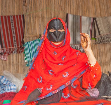 MÜZCAT, OMAN - 1 Şubat 2008: Umman 'da dönen kimliği belirsiz bir kadın. Dönme eski bir tekstil sanatıdır. Bitki, hayvan ya da sentetik lifler iplik oluşturmak için bir araya getirilir.. 