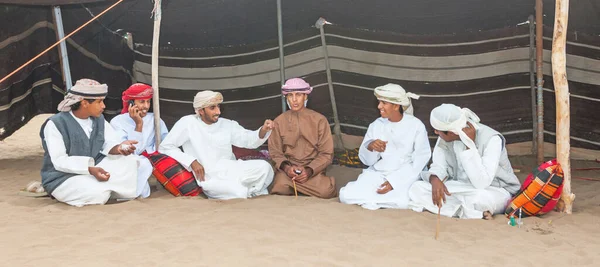 MÜZKAT, OMAN - 1 Şubat 2008: Umman 'daki çadırlarının önünde dinlenen kimliği belirsiz genç Ummanlı adamlar.