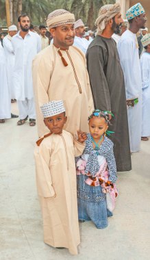 MÜZKAT, OMAN - 1 Şubat 2008: Umman Sultanlığı 'ndaki Muscat' ta, iki küçük çocuğuyla birlikte, kusursuz giyinmiş, gururlu bir Omani baba.