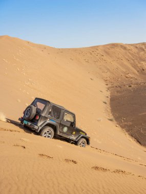 MÜZCAT INTERIOR, OMAN - 5 Mart 2006: Dubai kayıtlı bir Jeep Wrangler 4x4 aracı Umman Sultanlığı 'nın iç kesimlerinde bir kum tepeciği üzerinde pazarlık ediyor.