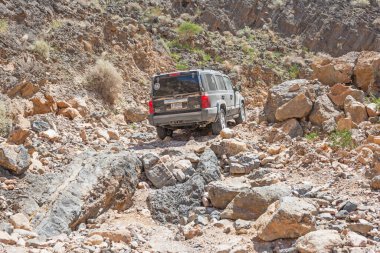 HAJAR dağları, OMAN - 5 Mart 2006 Dubai kayıtlı bir Jeep Komutanı 4x4 SUV Umman Sultanlığı 'nın Hajar Dağları' nda zorlu bir kayalık pistte arabuluculuk yapıyor..