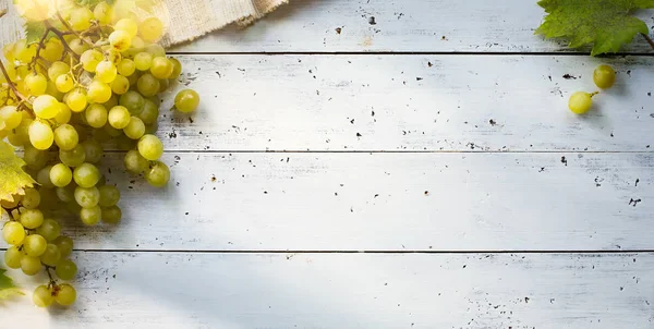 Uvas sobre mesa branca; condimentos de fundo da vinha — Fotografia de Stock