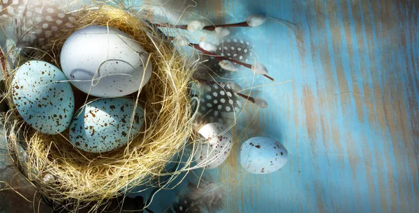 青いテーブルの上のイースターの卵をイースターの背景 — ストック写真