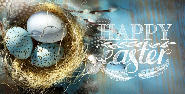 Feliz Pascua; Huevos de Pascua en cesta en el fondo de la mesa azul — Foto de Stock