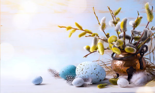 Feliz Pascua; Huevos de Pascua y flores de ramita en el respaldo de la mesa azul — Foto de Stock