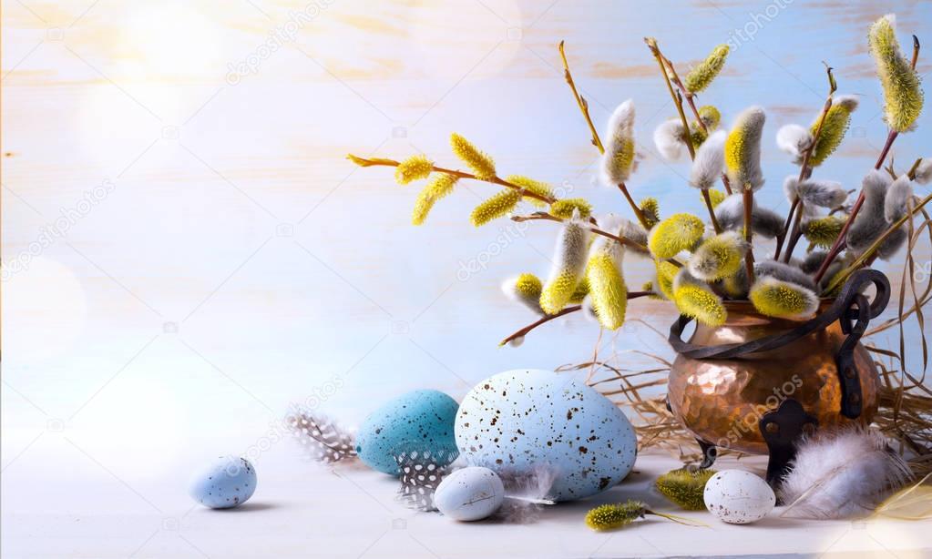 Happy Easter;  Easter eggs and sprig flowers on blue table backg