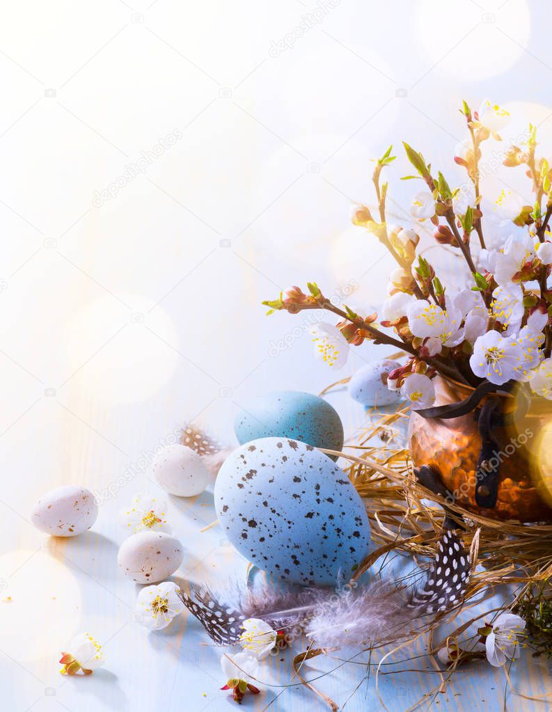 Happy Easter;  Easter eggs and sprig flowers on blue table backg