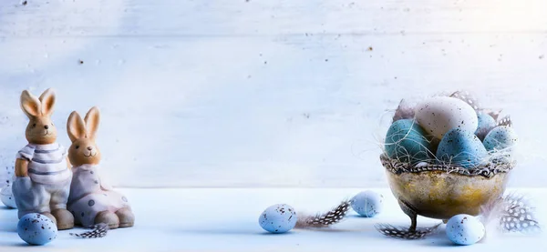 Feliz Páscoa; ovos de Páscoa e coelho de Páscoa na mesa azul backgr — Fotografia de Stock