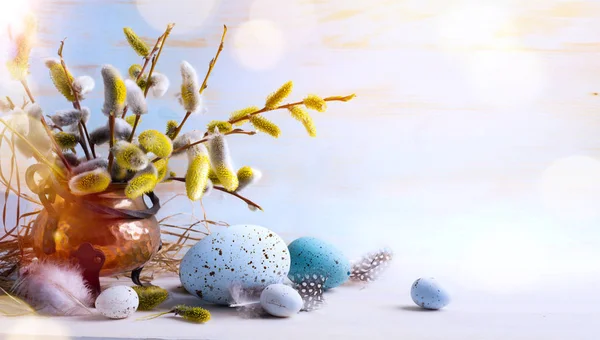 Feliz Páscoa; ovos de Páscoa e flores de raminho em backg mesa azul — Fotografia de Stock