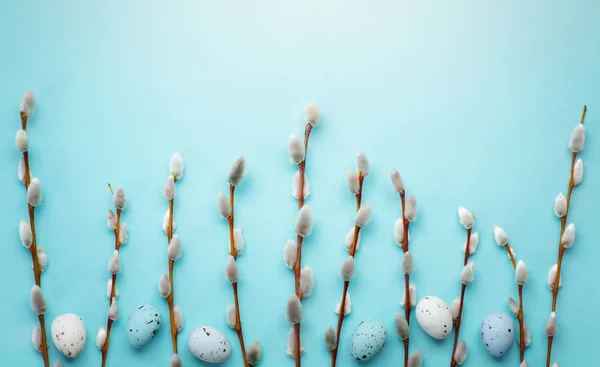 Пасхальный фон с пасхальными яйцами и весенними цветами на голубом фоне — стоковое фото