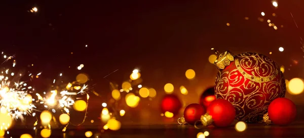 Decorazione natalizia rossa bauble e luci festive sul retro rosso — Foto Stock